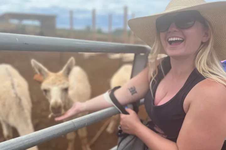 a woman standing next to a fence